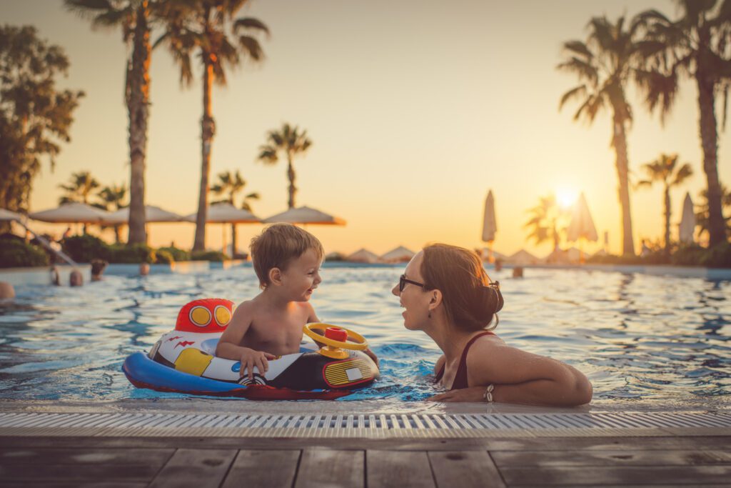Mother and son swimming in hotel pool