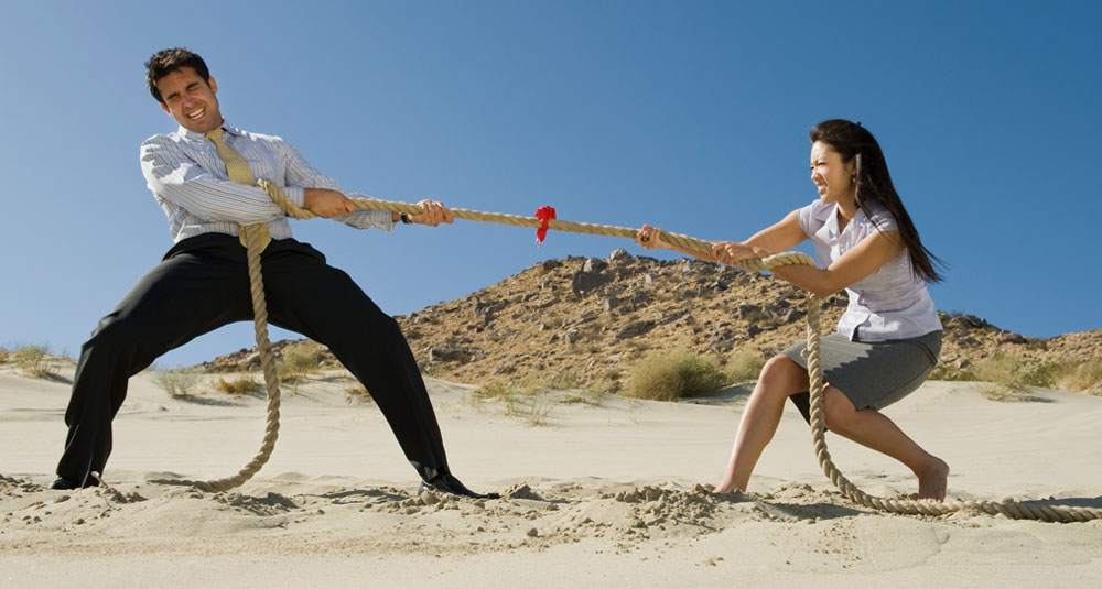 Two people pulling a rope in a game of tug-of-war.