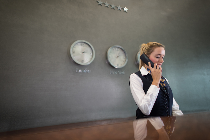 Hotel receptionist on phone behind desk