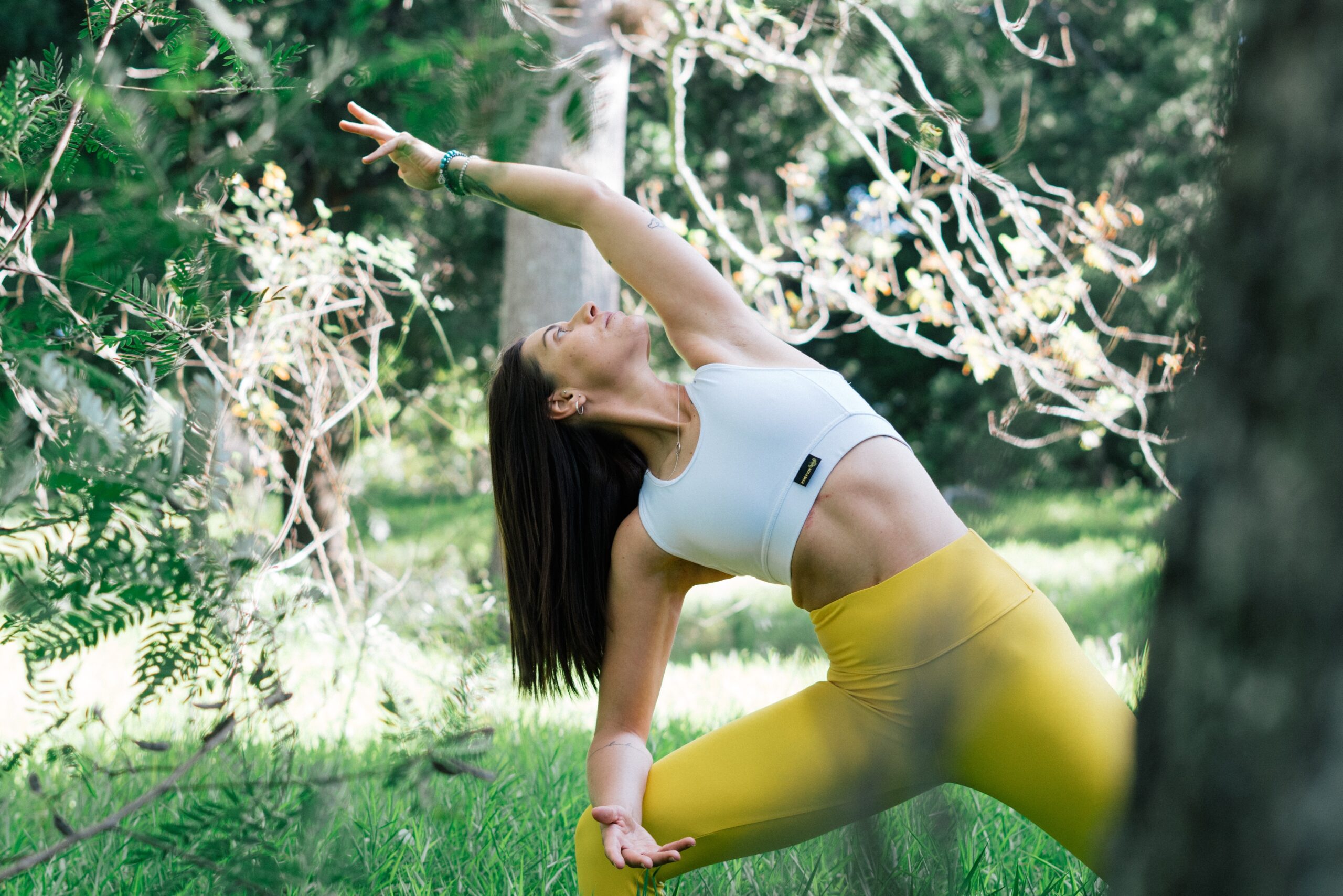 woman practicing yoga in the forest - a wellness tourism trend