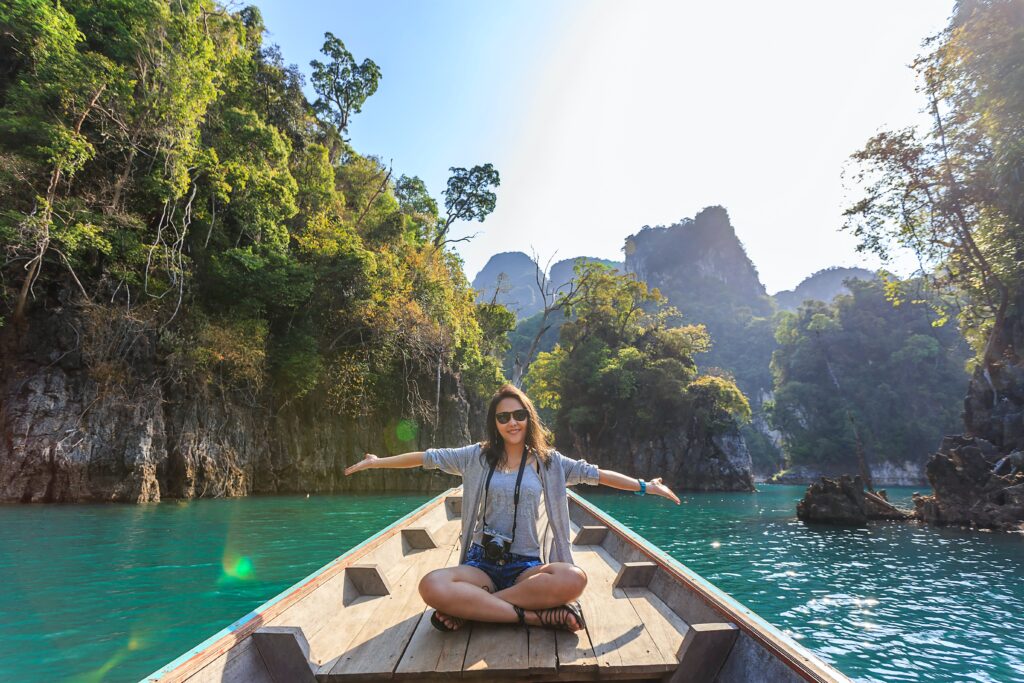 Young woman sitting on boat in remote destination: attracting younger hotel guests